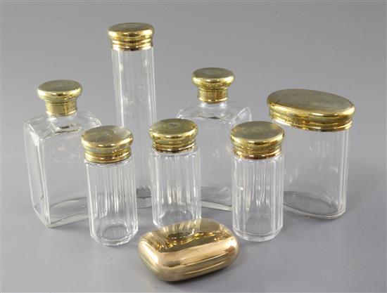 A George V Asprey & Co silver gilt-topped seven piece glass toilet set and an Asprey silver gilt soap box